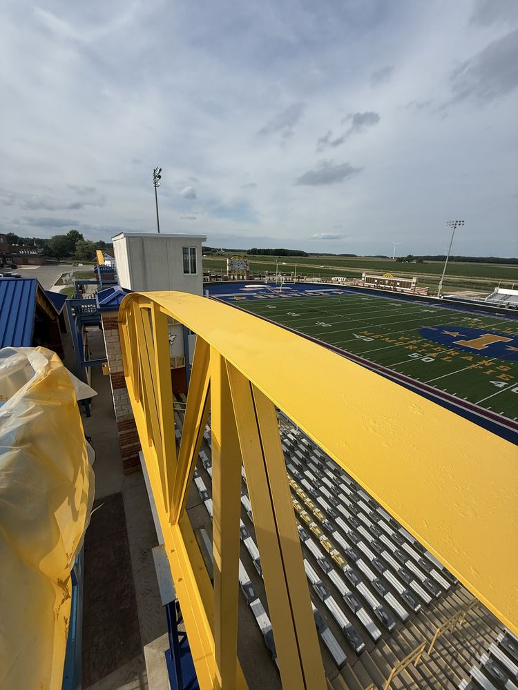 Bright yellow structural steel railing coated above a stadium